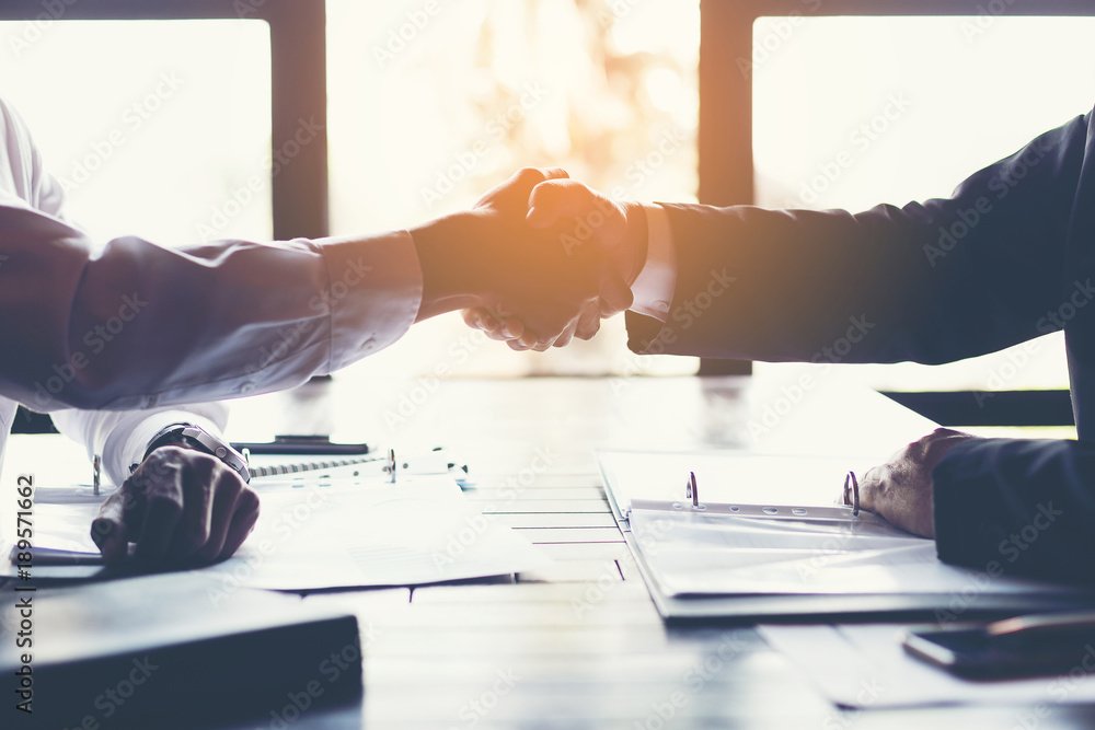 business partners handshaking after business success negotiation at meeting room.