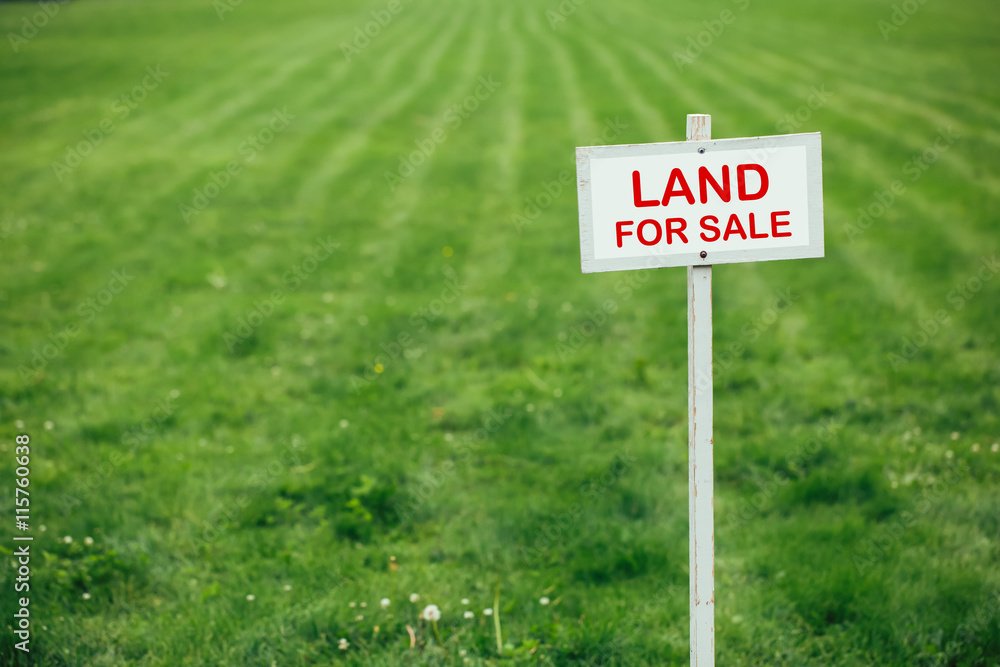 land for sale sign against trimmed lawn background